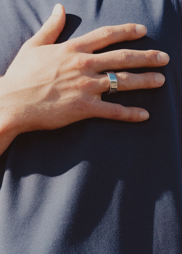 Hand mit Oura Ring 4 liegt auf der Brust