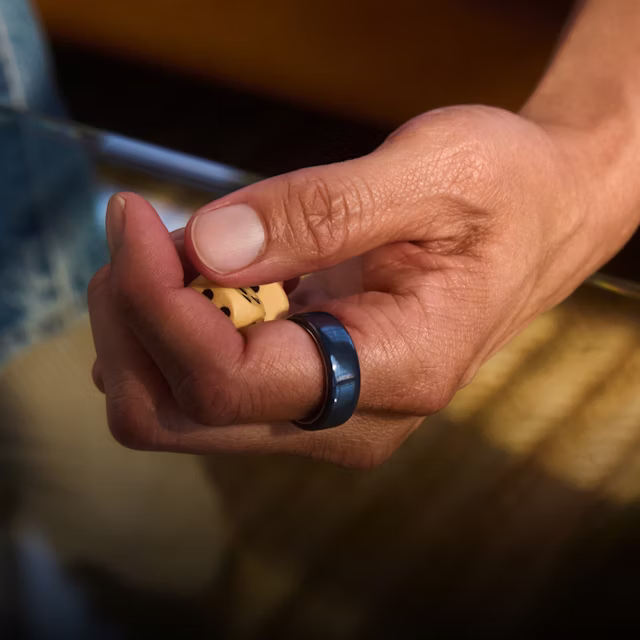 Nahaufnahme der Hand einer Person mit einem Midnight Oura Ring 4 Ceramic am Finger